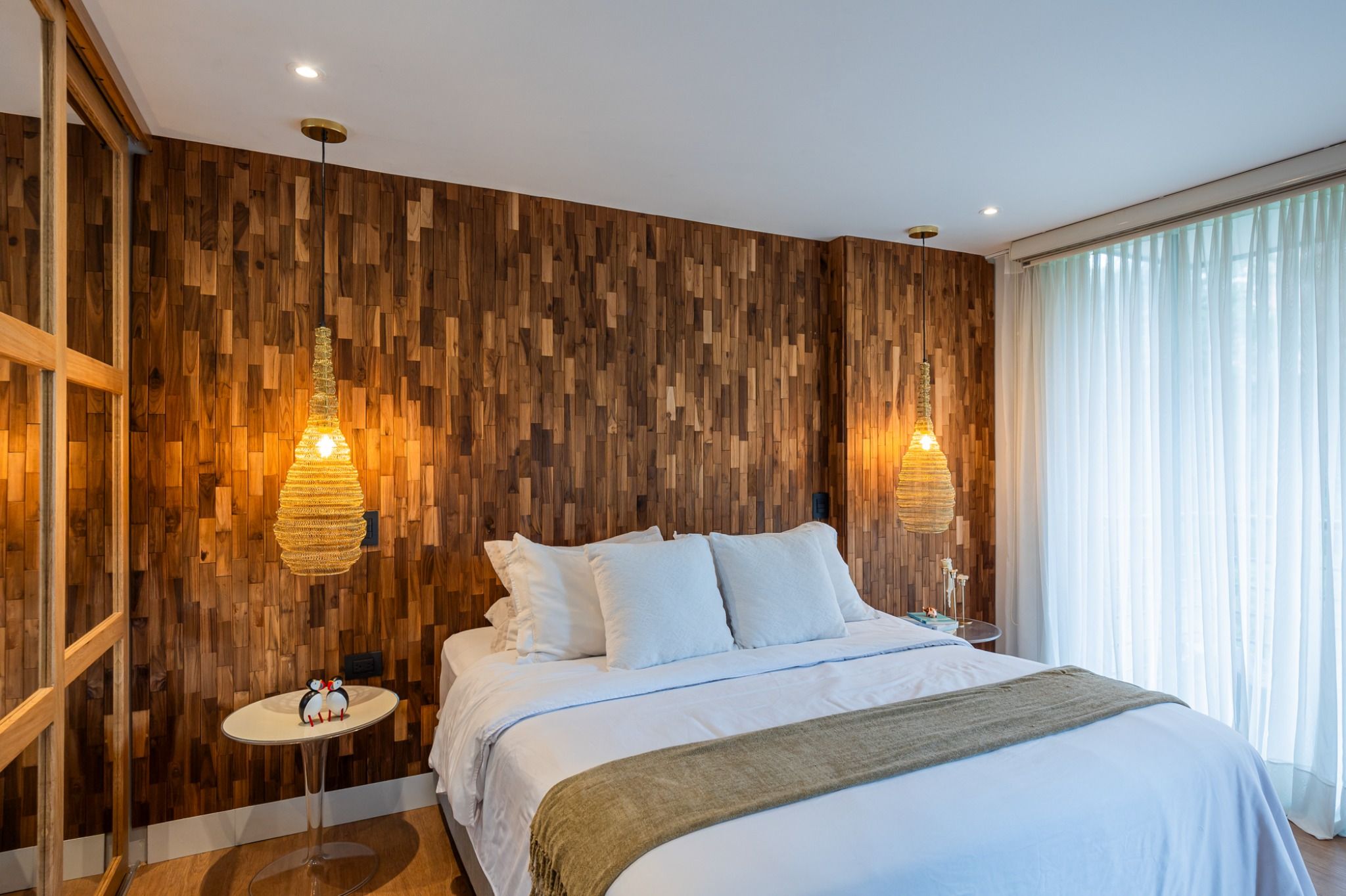 Bedroom feature wall in Oasis & Haus Dark teak panels with pendant lights